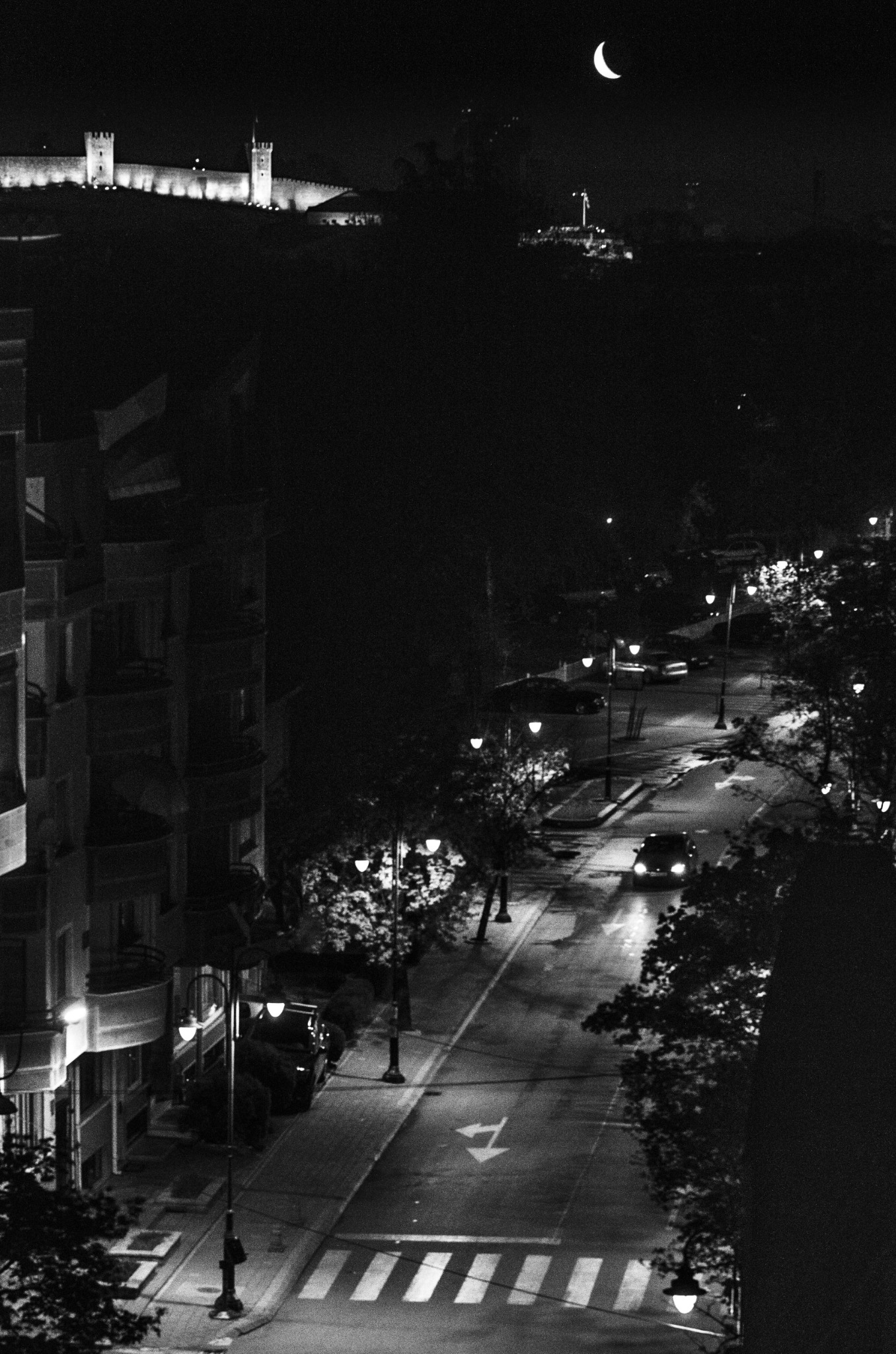 Night street beneath a crescent moon